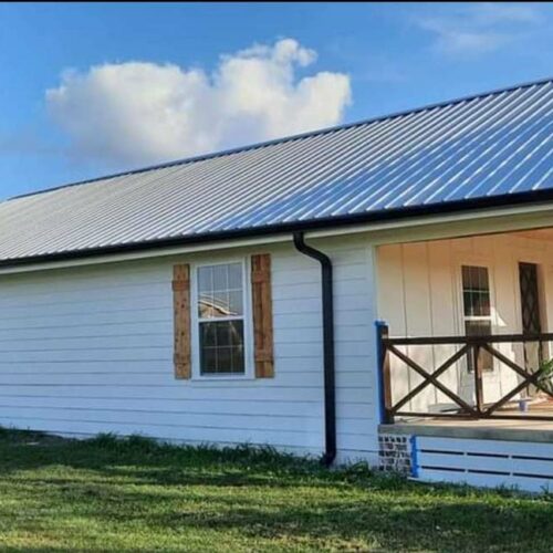 home with metal roofing and gutters