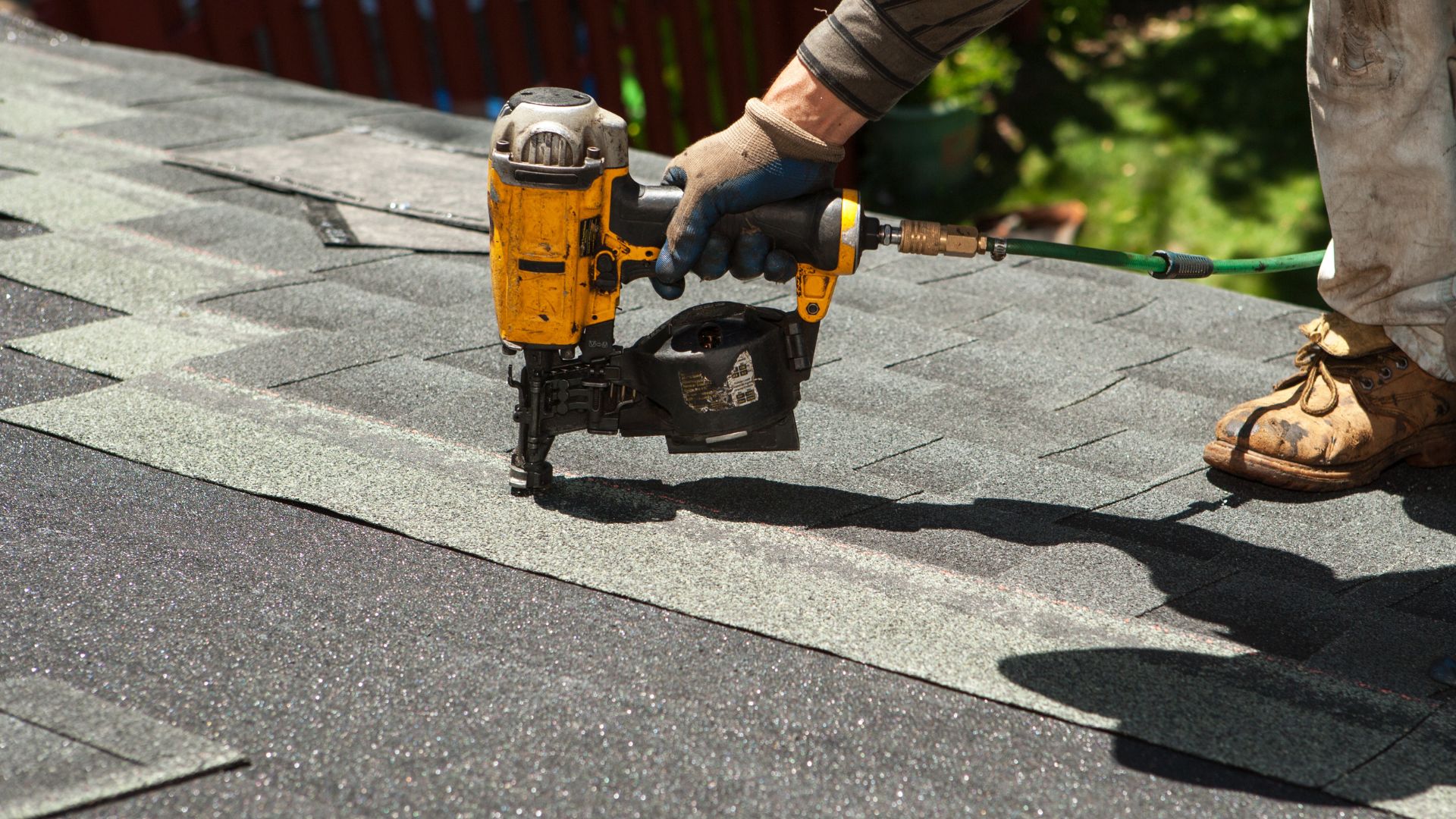 person doing maintenance on a roof with a nail gun